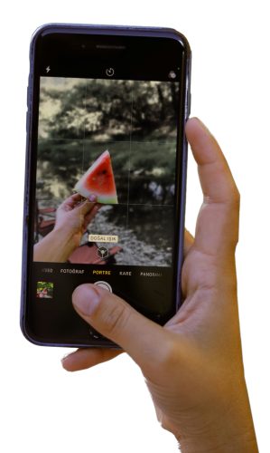 Cell phone taking picture of a watermelon slice